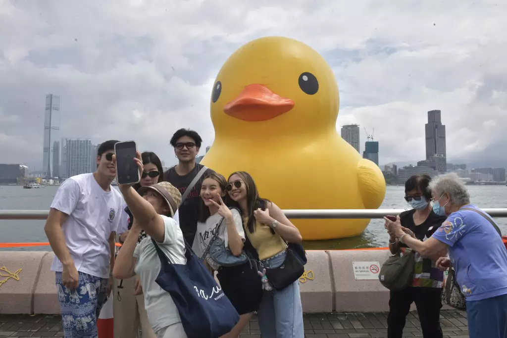 黃色橡皮鴨在維港展出的首個周日，市民與「回復單身」的大鴨打卡。