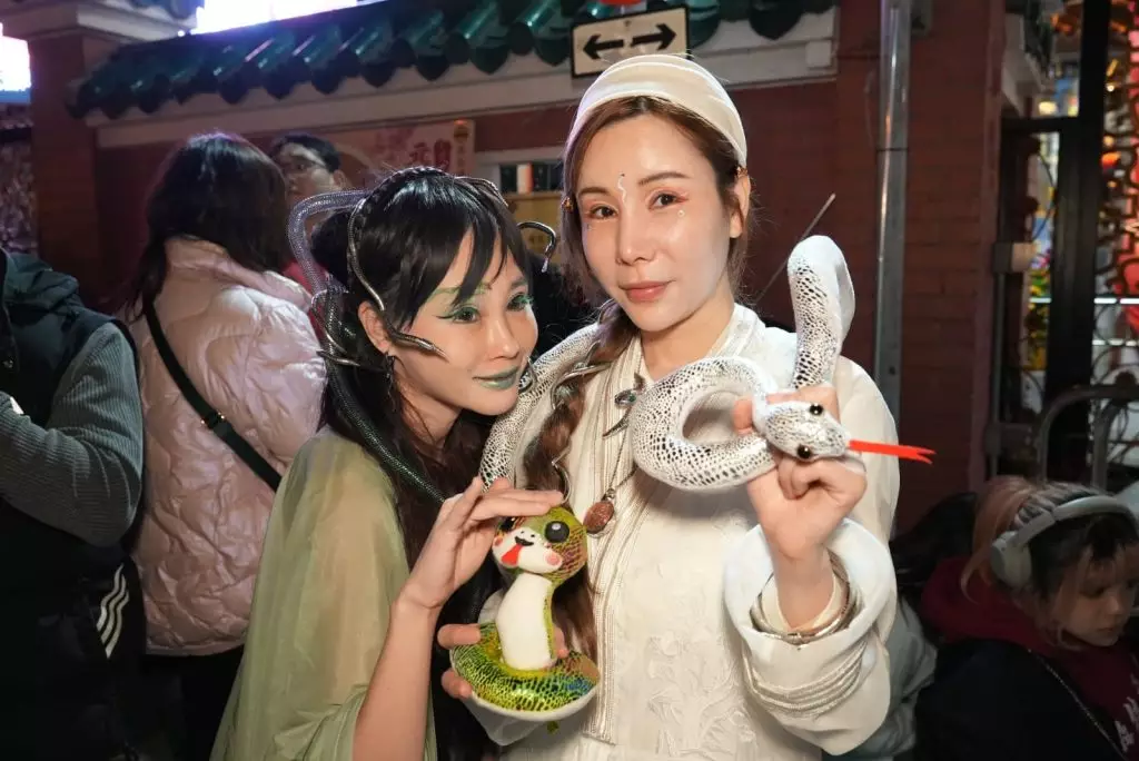 艾美琦(右)、李子彤(左)爭上黃大仙祠頭炷香。巴士的報記者攝