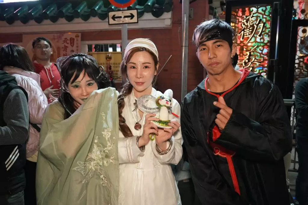 艾美琦(中)、李子彤(左)爭上黃大仙祠頭炷香。巴士的報記者攝