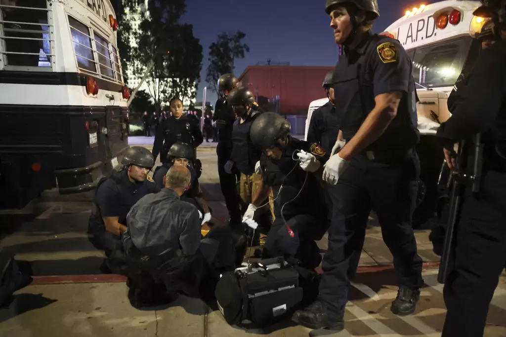 洛杉磯市中心部分地區的宵禁令就延長,警方說,超過200人在星期二晚被捕。AP圖片