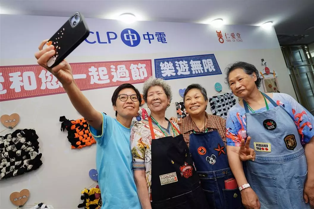 長者們於升級再造展示區與作品合照。中電圖片