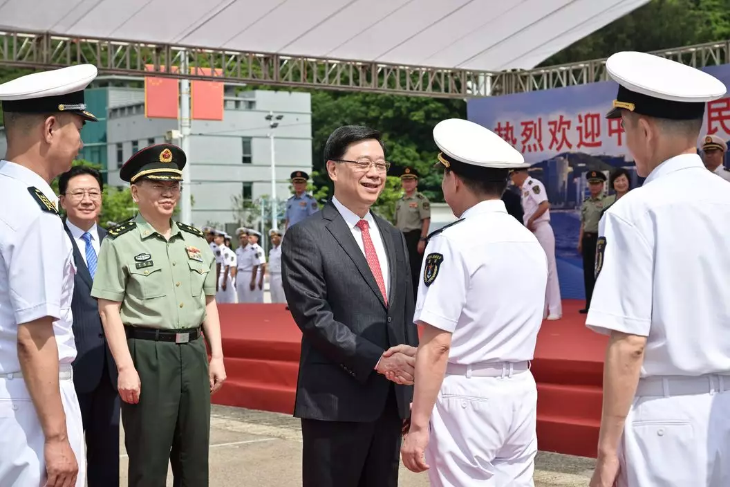 李家超(左四)歡迎中國人民解放軍海軍副政治委員程堅海軍中將(左五)登岸。政府新聞網圖片