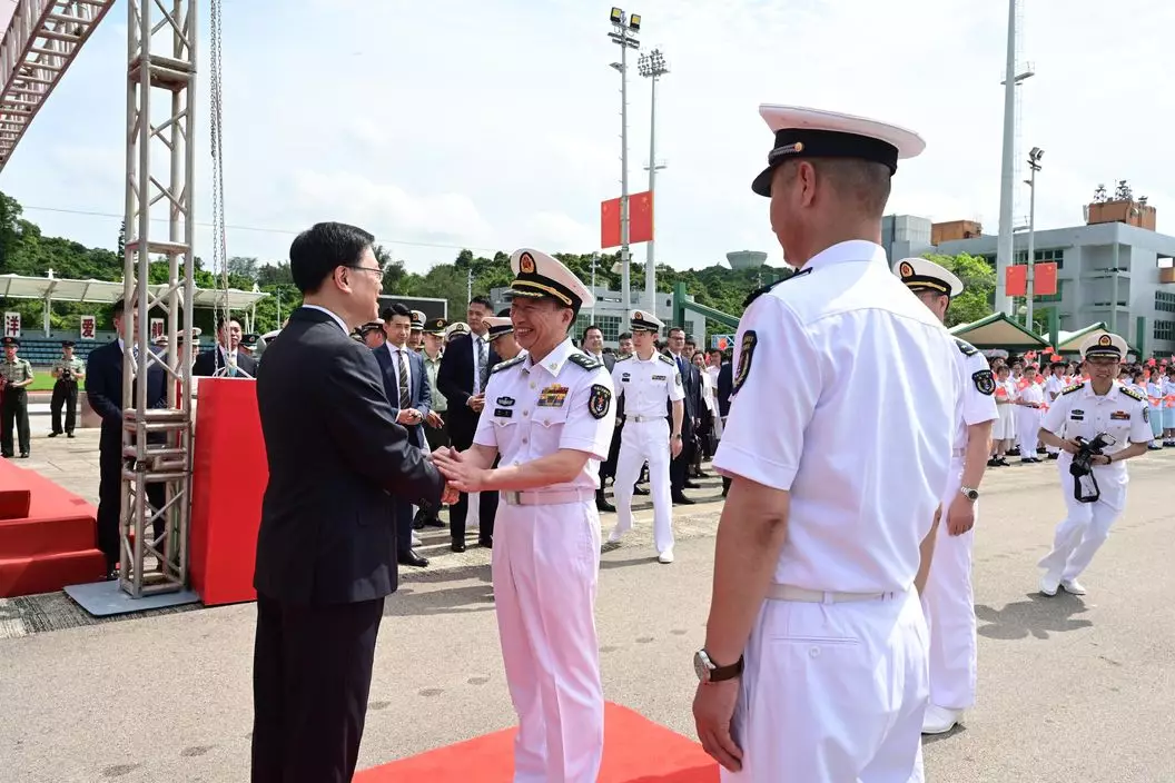李家超(左一)歡迎中國人民解放軍海軍副政治委員程堅海軍中將(左二)登岸。政府新聞網圖片