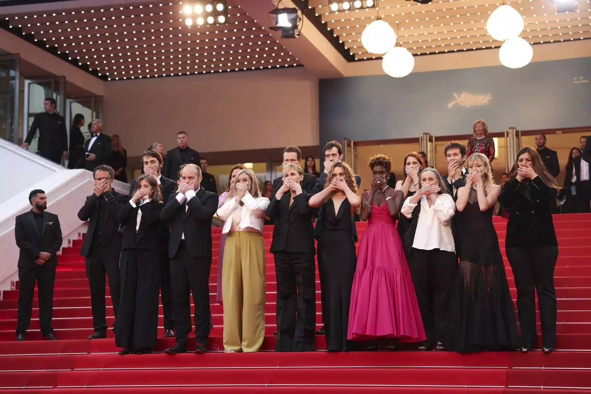 "Me Too" director Judith Godreche, center, poses with hands covering their mouth upon arrival at the premiere of the film 'Furiosa: A Mad Max Saga' at the 77th international film festival, Cannes, southern France, Wednesday, May 15, 2024. (Photo by Vianney Le Caer/Invision/AP)