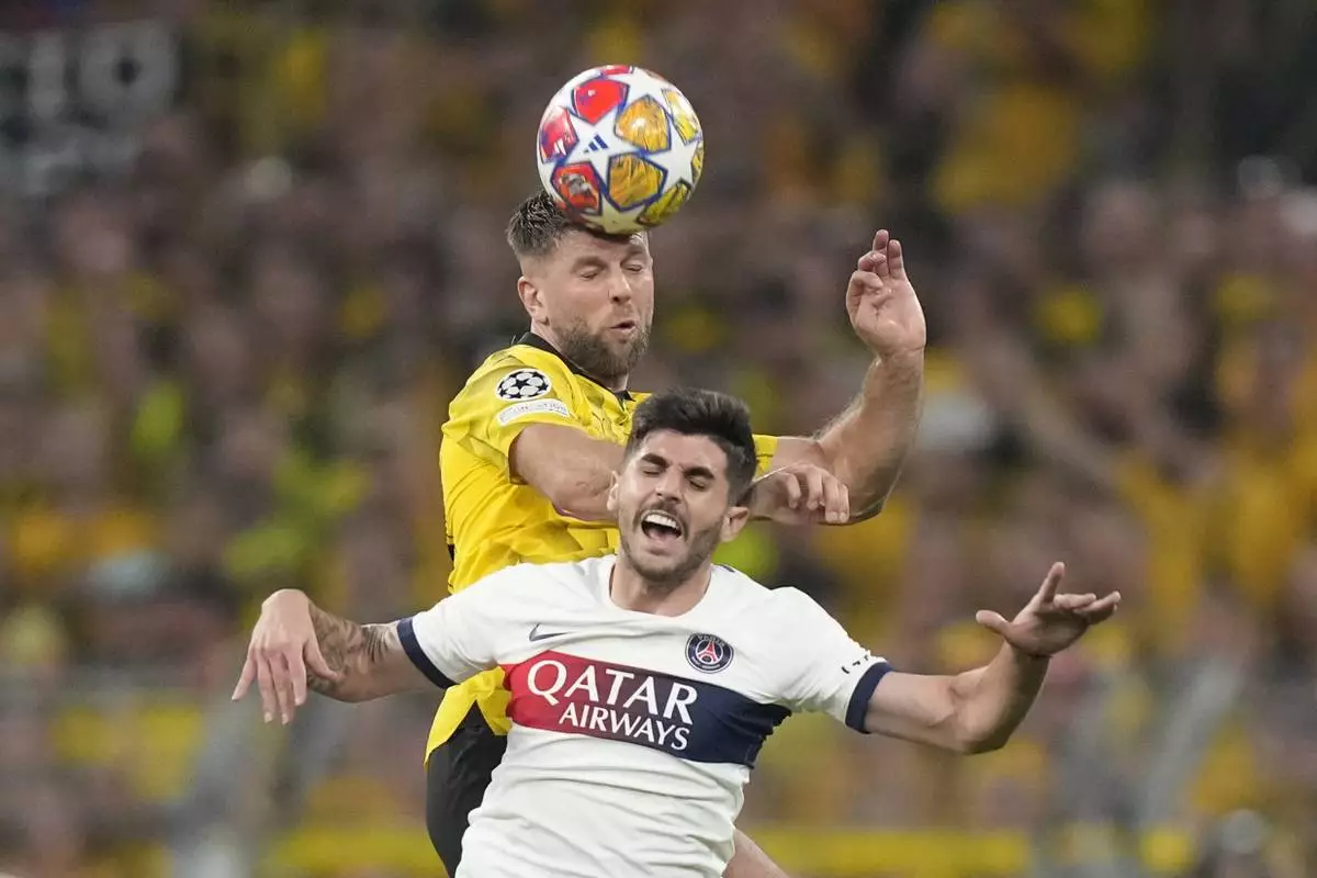 PSG&apos;s Lucas Beraldo jumps for a header with Dortmund&apos;s Niclas Fue...