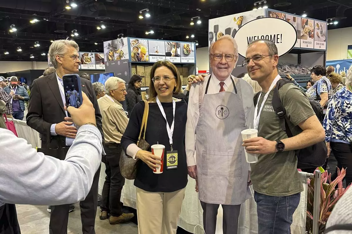 Berkshire Hathaway shareholders pose with a cutout poster of CEO Warren Buffett, Friday, May 3, 2024, in Omaha, Neb., one day ahead of the annual shareholders meeting. (AP Photo/Josh Funk)