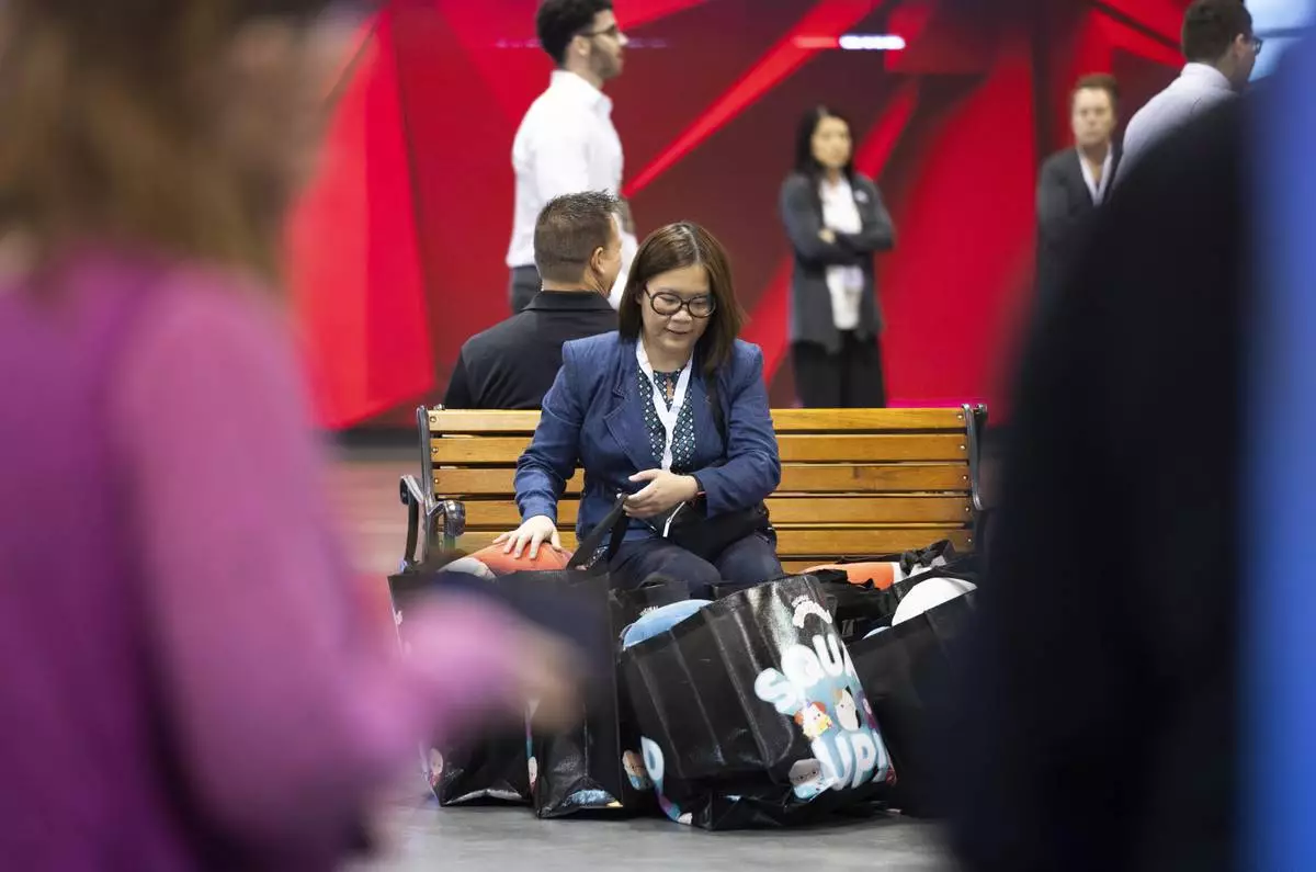 Jennifer Cua of Las Vegas sits with her purchases from Squishmallows during the Berkshire Hathaway annual meeting on Saturday, May 4, 2024, in Omaha, Neb. (AP Photo/Rebecca S. Gratz)