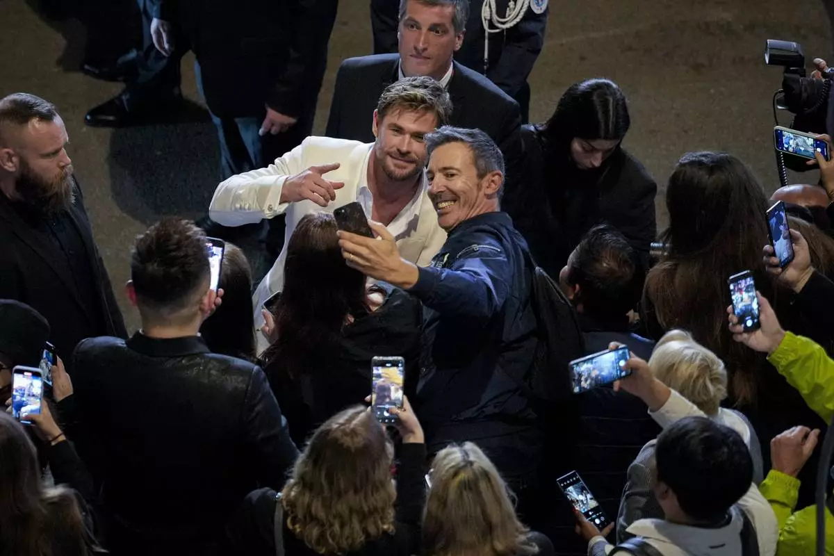 Chris Hemsworth, left centre, poses for a selfie upon departure from the premiere of the film 'Furiosa: A Mad Max Saga' at the 77th international film festival, Cannes, southern France, Wednesday, May 15, 2024. (Photo by Andreea Alexandru/Invision/AP)