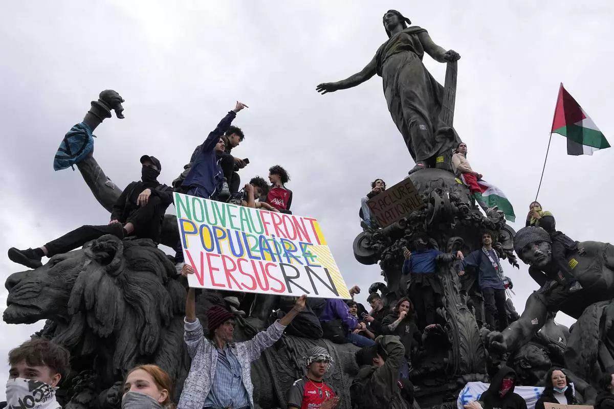 Protesters hold an anti-far right banner during a rally in Paris, Saturday, June 15, 2024. Anti-racism groups joined French unions and a brand-new left-wing coalition in protests in Paris and across France on Saturday against the surging nationalist far right as frenzied campaigning is underway ahead of snap parliamentary elections. (AP Photo/Michel Euler)