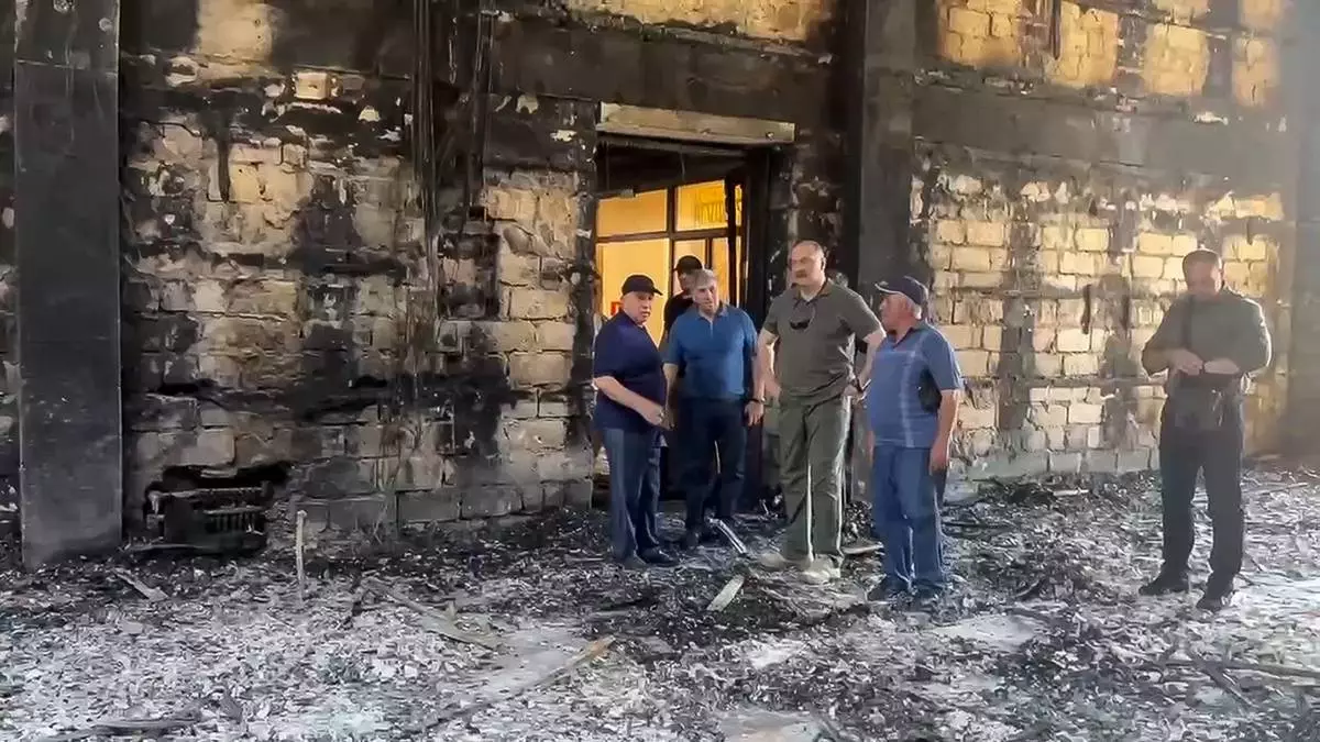 In this photo taken from video released by The Telegram Channel of the head of Dagestan Republic of Russia on Monday, June 24, 2024, the head of Dagestan Republic Sergei Melikov, center, visits the damaged the Kele-Numaz synagogue in Derbent after a counter-terrorist operation in republic of Dagestan, Russia. More than 15 police officers and several civilians, including an Orthodox priest, were killed by armed militants in Russia's southern republic of Dagestan on Sunday, its governor Sergei Melikov said in a video statement early Monday. The gunmen opened fire on two Orthodox churches, a synagogue and a police post in two cities, according to the authorities. (The Telegram Channel of the head of Dagestan Republic of Russia via AP)