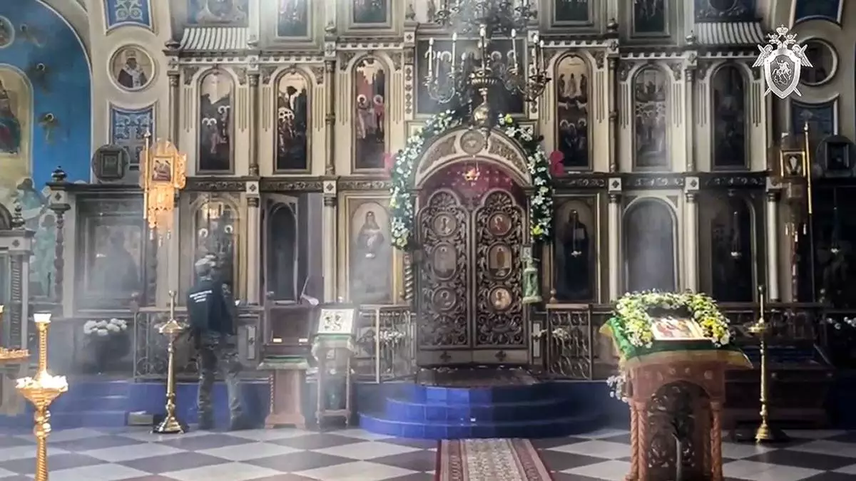 In this photo taken from video released by Russian Investigative Committee on Monday, June 24, 2024, a Russian Investigative Committee employee works inside a damaged by armed militants Orthodox Church in Makhachkala after a counter-terrorist operation in republic of Dagestan, Russia. Multiple police officers and several civilians, including an Orthodox priest, were killed by armed militants in Russia's southern republic of Dagestan on Sunday, its governor Sergei Melikov said in a video statement early Monday. (Russian Investigative Committee via AP)