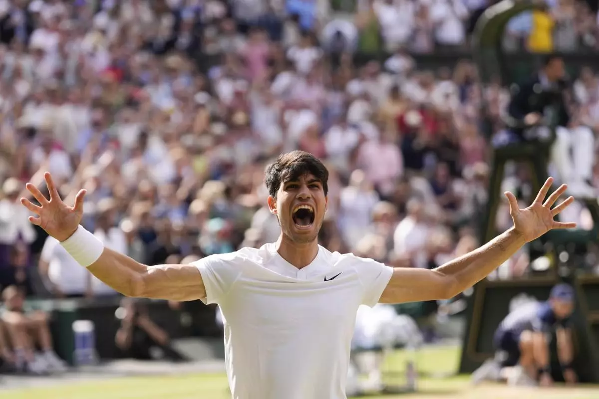 Carlos Alcaraz of Spain celebrates after defeating Novak Djokovic of Serbia in the men's singles final at the Wimbledon tennis championships in London, Sunday, July 14, 2024. (AP Photo/Alberto Pezzali)