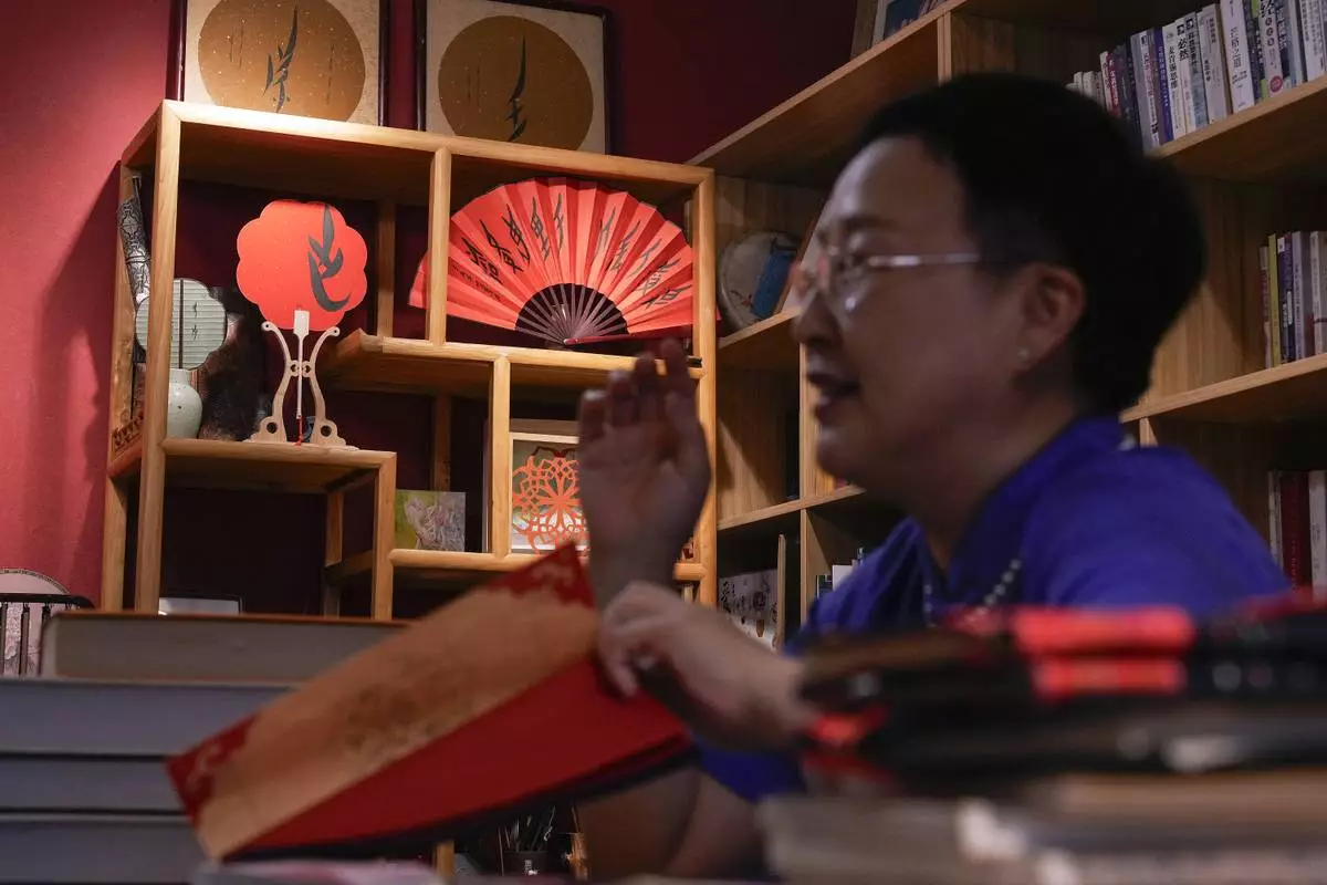 Xu Yan, an author of a textbook on nüshu, a centuries-old secret script, talks about the script at her studio in Beijing on July 11, 2024. (AP Photo/Andy Wong)