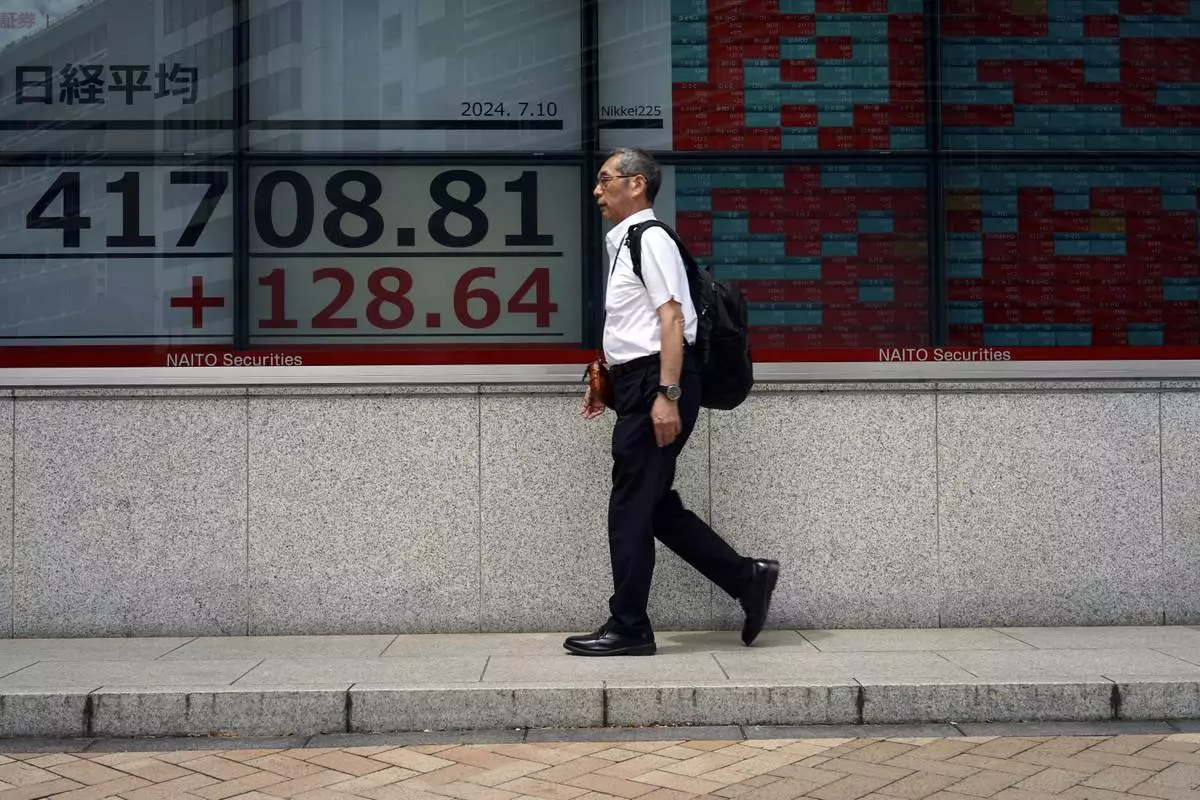 A person walks in front of an electronic stock board showing Japan's Nikkei index at a securities firm Wednesday, July 10, 2024, in Tokyo. (AP Photo/Eugene Hoshiko)