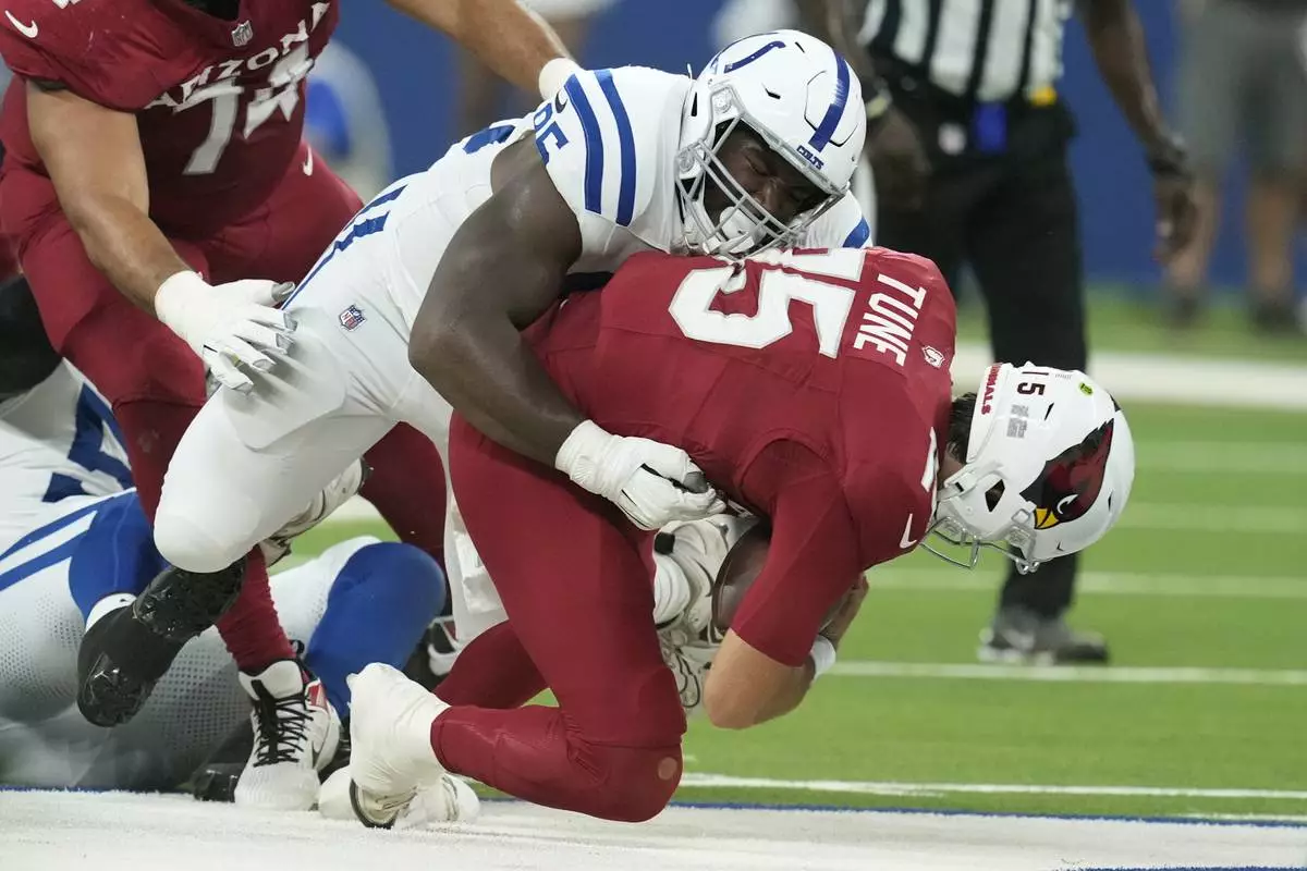 Indianapolis Colts defensive tackle Adetomiwa Adebawore, left, sacks Arizona Cardinals quarterback Clayton Tune, right, during the first half of a preseason NFL football game, Saturday, Aug. 17, 2024, in Indianapolis. (AP Photo/Darron Cummings)