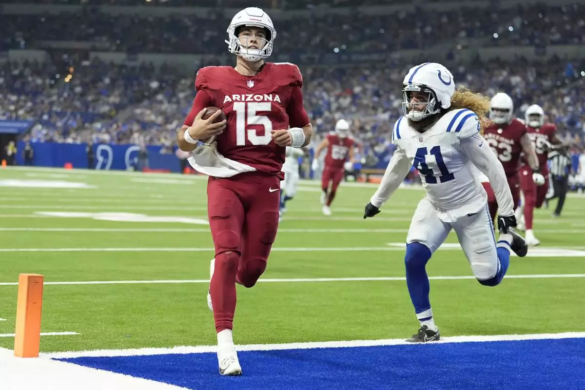 Arizona Cardinals quarterback Clayton Tune (15) scores a touchdown against Indianapolis Colts linebacker Grant Stuard (41) during the first half of a preseason NFL football game, Sunday, Aug. 18, 2024, in Indianapolis. (AP Photo/Michael Conroy)