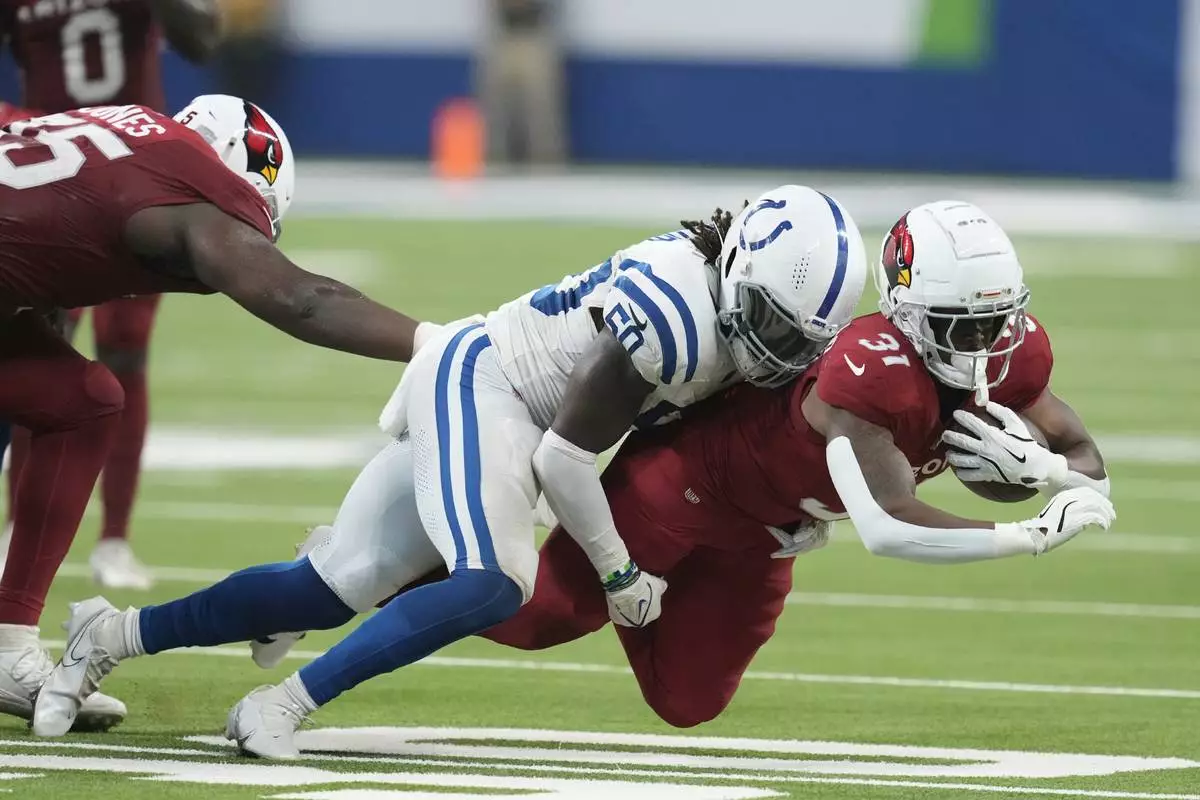 Indianapolis Colts linebacker Segun Olubi (50) tackles Arizona Cardinals running back Emari Demercado (31) during the first half of a preseason NFL football game, Saturday, Aug. 17, 2024, in Indianapolis. (AP Photo/Darron Cummings)