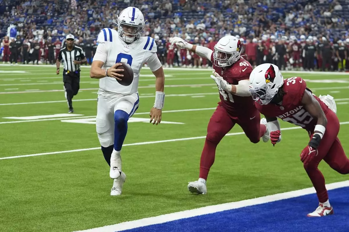 Indianapolis Colts quarterback Jason Bean (8) runs for a touchdown by beating Arizona Cardinals linebacker Markus Bailey (41) and Cardinals safety Verone McKinley III, right, during the second half of a preseason NFL football game, Saturday, Aug. 17, 2024, in Indianapolis. (AP Photo/Darron Cummings)