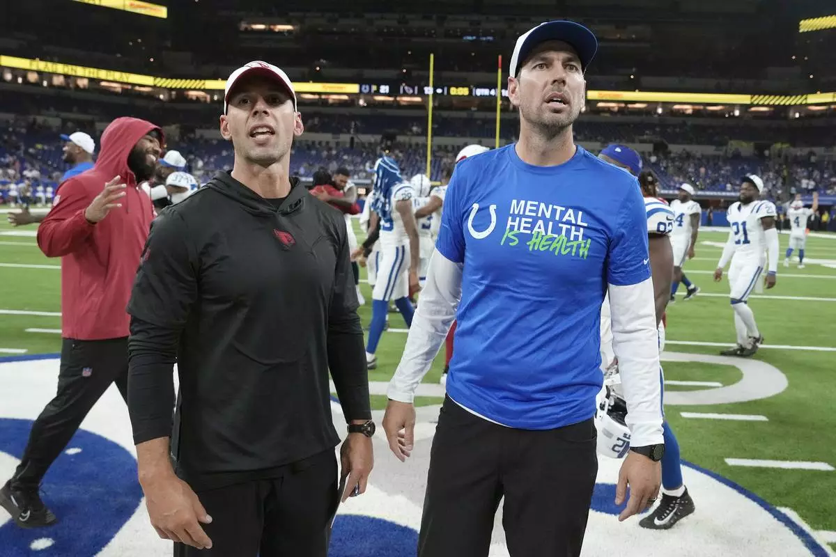 Arizona Cardinals head coach Jonathan Gannon, left, pauses with Indianapolis Colts head coach Shane Steichen, right, after a preseason NFL football game, Sunday, Aug. 18, 2024, in Indianapolis. The Colts won 21-13. (AP Photo/Michael Conroy )