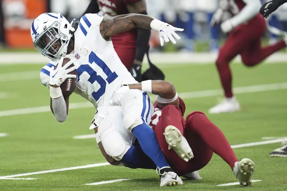 Indianapolis Colts running back Tyler Goodson (31) gets pulled down by Arizona Cardinals safety Dadrion Taylor-Demerson during the first half of a preseason NFL football game, Saturday, Aug. 17, 2024, in Indianapolis. (AP Photo/Michael Conroy)