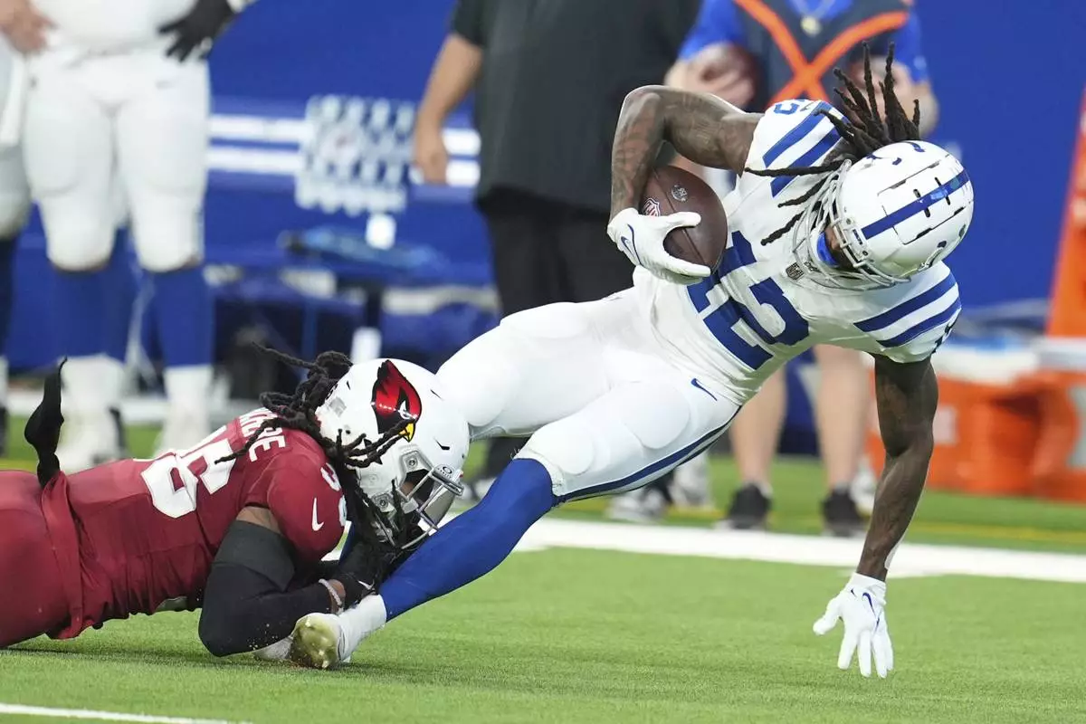 Indianapolis Colts wide receiver Tyrie Cleveland (12) is tackled by Arizona Cardinals safety Andre Chachere during the first half of a preseason NFL football game, Saturday, Aug. 17, 2024, in Indianapolis. (AP Photo/Michael Conroy)