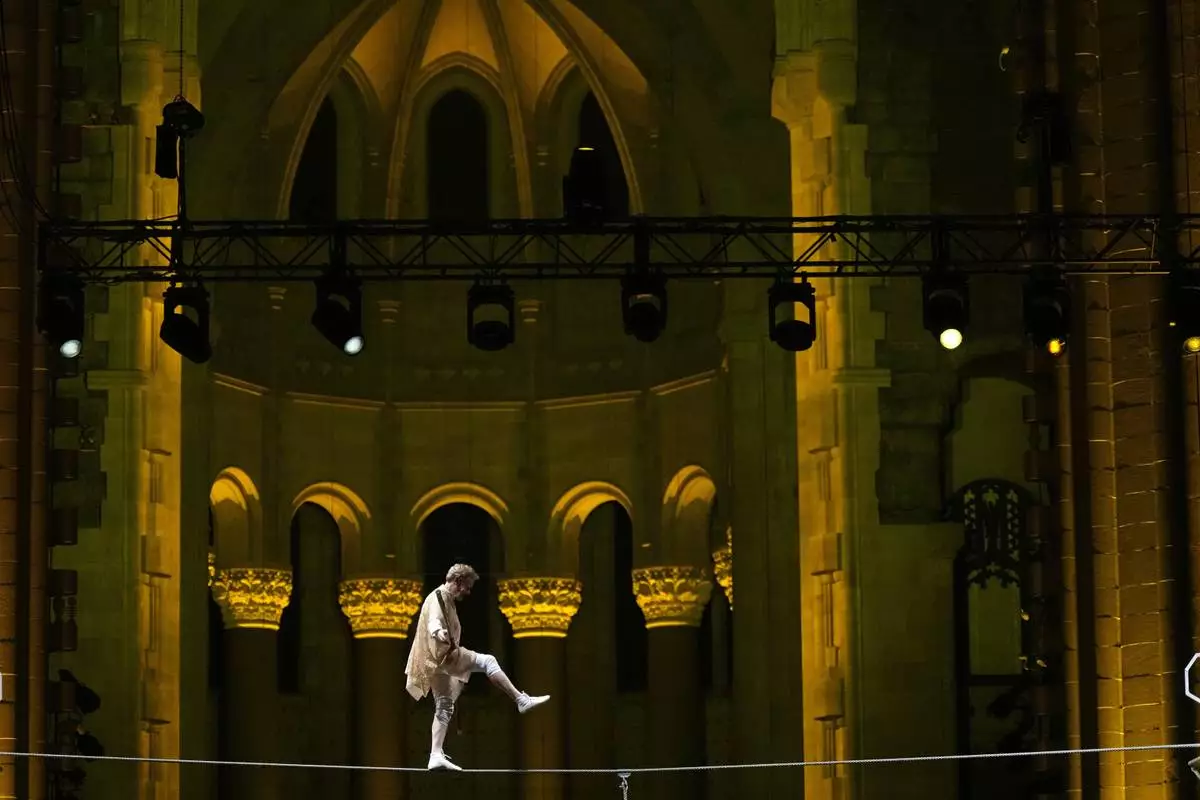 Philippe Petit walks a tightrope inside the Cathedral Church of St. John the Divine to mark the 50th anniversary of his World Trade Center Twin Towers high-wire walk, on Wednesday, Aug. 7, 2024, in New York. (Photo by Charles Sykes/Invision/AP)