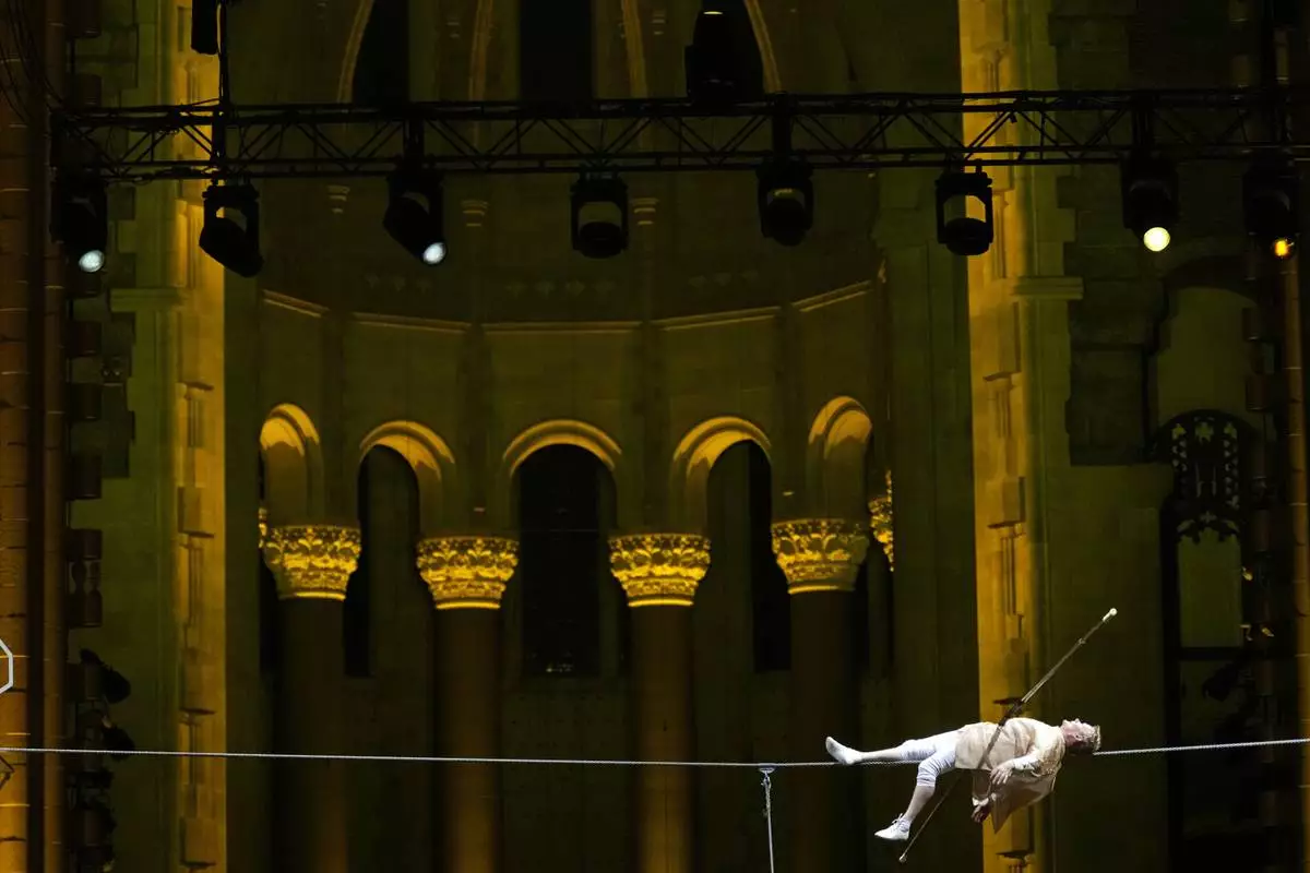 Philippe Petit lies on a tightrope inside the Cathedral Church of St. John the Divine to mark the 50th anniversary of his World Trade Center Twin Towers high-wire walk, on Wednesday, Aug. 7, 2024, in New York. (Photo by Charles Sykes/Invision/AP)