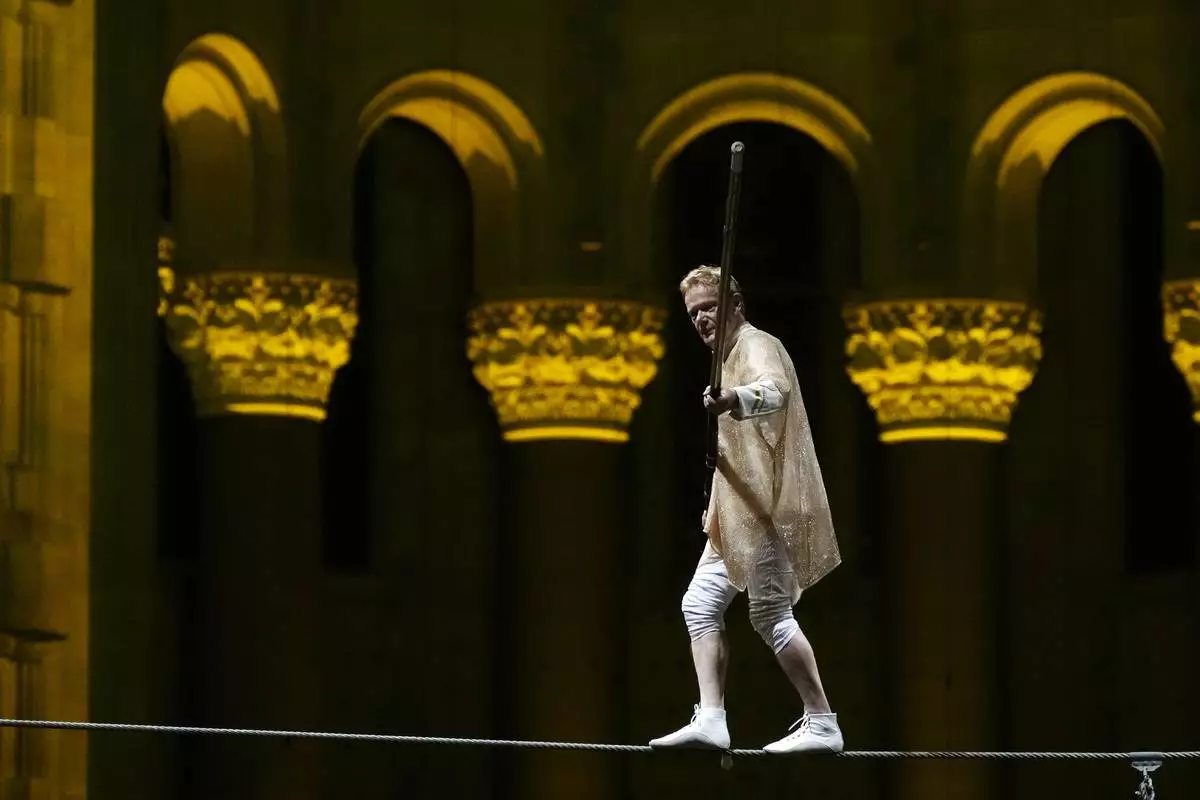 Philippe Petit walks a tightrope inside the Cathedral Church of St. John the Divine to mark the 50th anniversary of his World Trade Center Twin Towers high-wire walk, on Wednesday, Aug. 7, 2024, in New York. (Photo by Charles Sykes/Invision/AP)