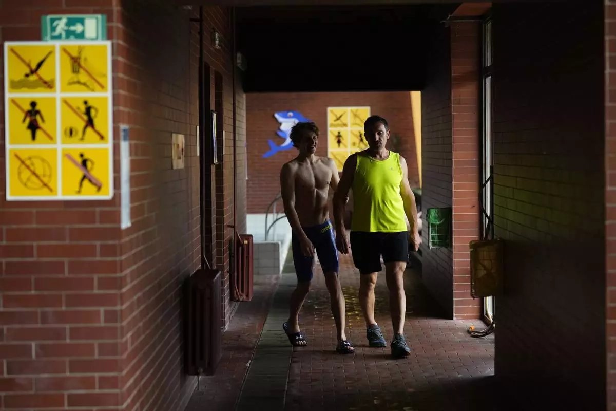 David Kratochvil, a teenage swimmer who prepares for the Paralympic Games in Paris, accompanied by his father Jiri arrives for his training in Tachov, Czech Republic, Wednesday, July 3, 2024. (AP Photo/Petr David Josek)