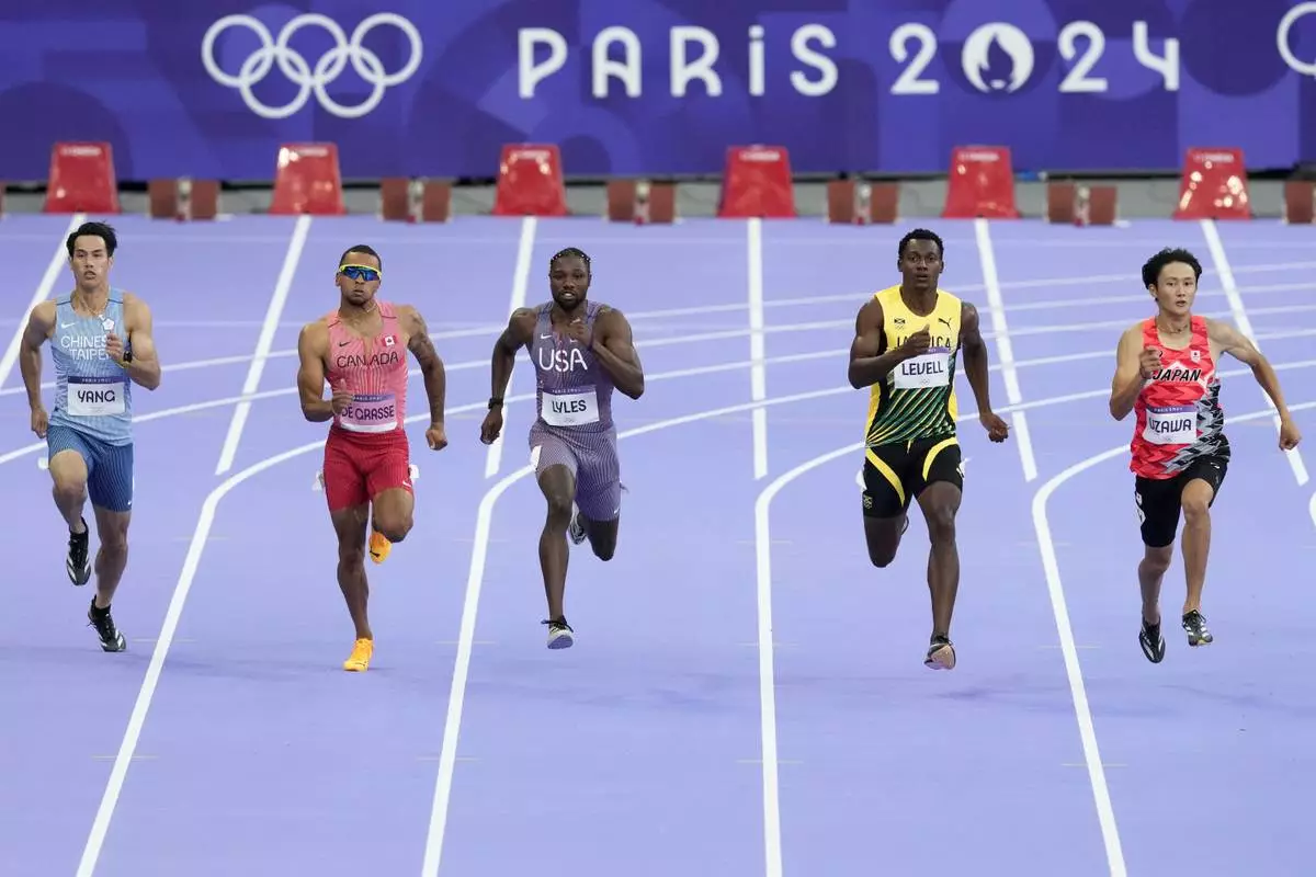 Chun-Han Yang, of Taiwan, Andre de Grasse, of Canada, Noah Lyles, of the United States, Bryan Levell, of Jamaica, and Towa Uzawa, of Japan, run in a men's 200 meters round 1 heat at the 2024 Summer Olympics, Monday, Aug. 5, 2024, in Saint-Denis, France. (AP Photo/Martin Meissner)