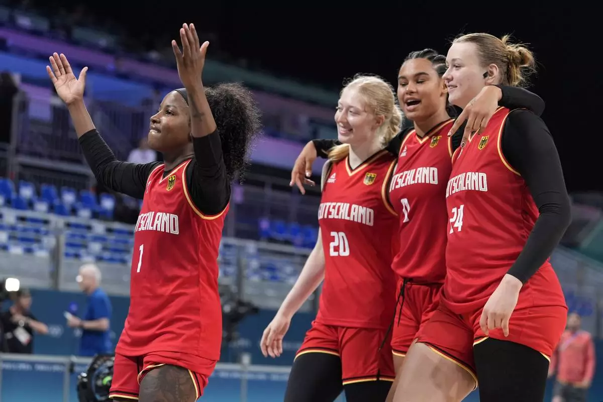 Germany's Alexis Peterson (1) celebrates withe teammates Germany's Frieda Buhner (20), Germany's Satou Sabally (0) and Germany's Lina Sontag after Germany defeated Japan in a women's basketball game at the 2024 Summer Olympics, Thursday, Aug. 1, 2024, in Villeneuve-d'Ascq, France. (AP Photo/Michael Conroy)