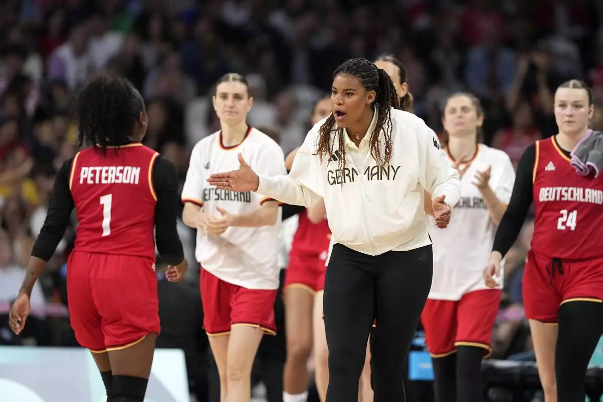 Germany's Nyara Sabally, center, congratulates Germany's Alexis Peterson during a timeout during a women's basketball game at the 2024 Summer Olympics, Thursday, Aug. 1, 2024, in Villeneuve-d'Ascq, France. (AP Photo/Michael Conroy)