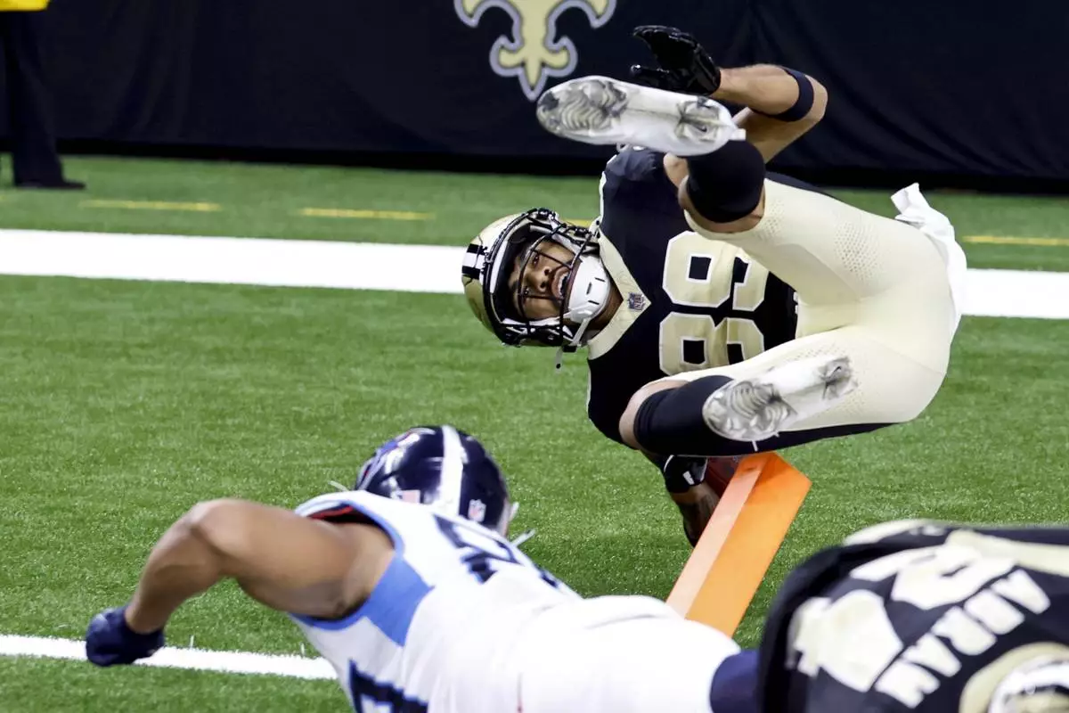 Samson Nacua of the New Orleans Saints (top) is ejected from the field by Thomas Odukoya of the Tennessee Titans (bottom left) just before the goal line as he returns a missed field goal attempt during the first half of an NFL football game, Sunday, Aug. 25, 2024, in New Orleans. (AP Photo/Butch Dill)