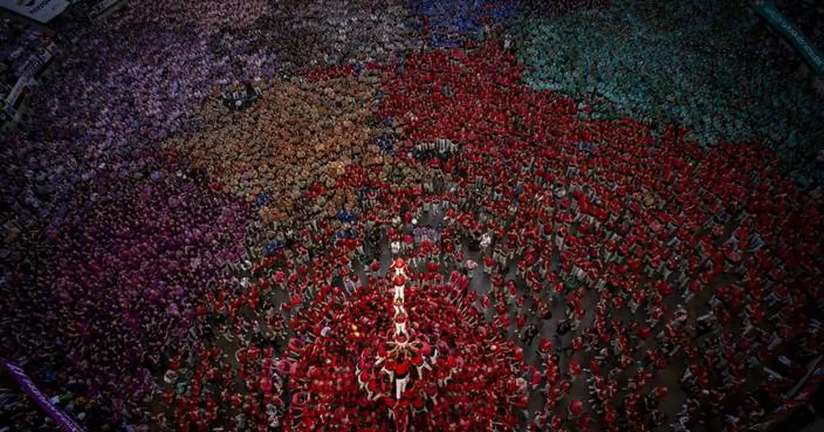 An AP photographer gets the light just right from a perch up high above a human tower competition