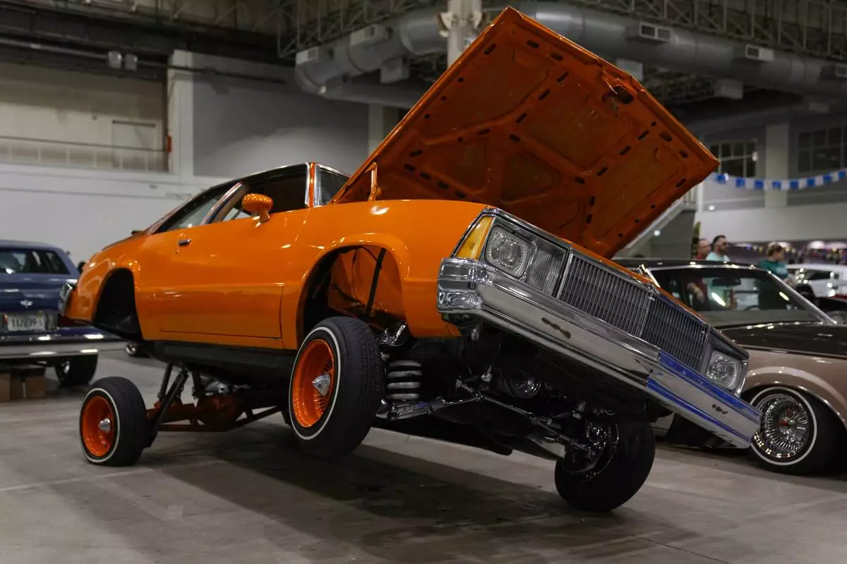 An orange lowrider car is on display at the Slow &amp; Low Chicago Lowrider Festival, Saturday, Oct. 12, 2024, at Navy Pier in Chicago. (AP Photo/Erin Hooley)