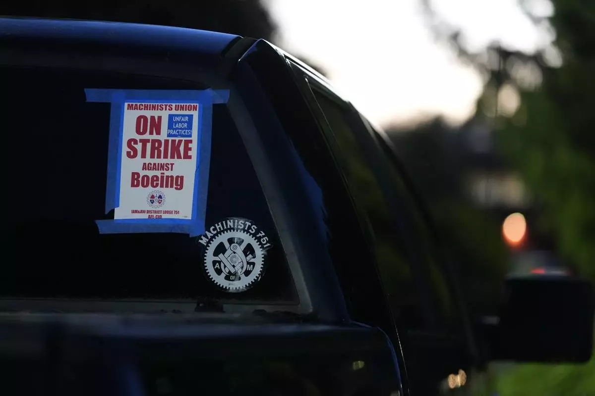 A truck displays a small strike sign in the parking lot of the Aerospace Machinists Union hall as Boeing employees arrive to vote on a new contract offer from the company Monday, Nov. 4, 2024, in Renton, Wash. (AP Photo/Lindsey Wasson)