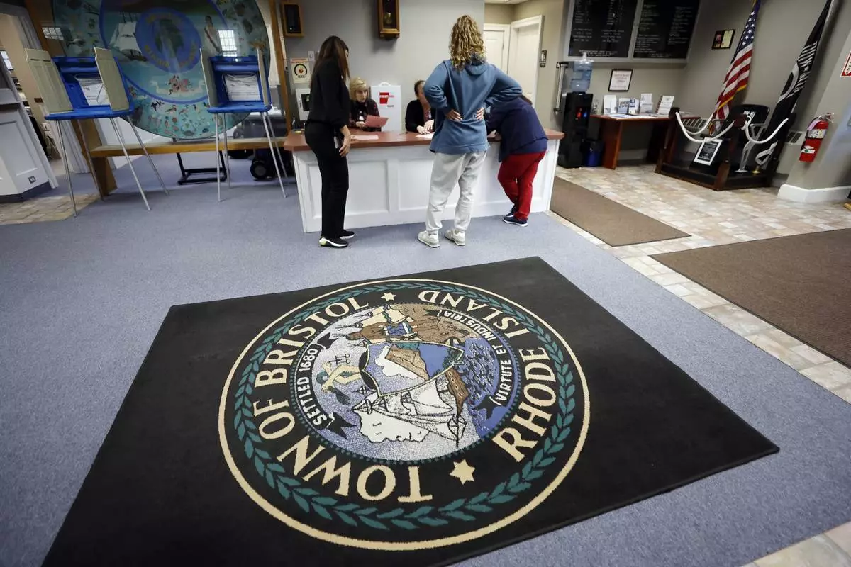 A woman registers for a provisional ballot on Election Day, Tuesday, Nov. 5, 2024, at the Town Hall in Bristol, R.I. (AP Photo/Michael Dwyer)