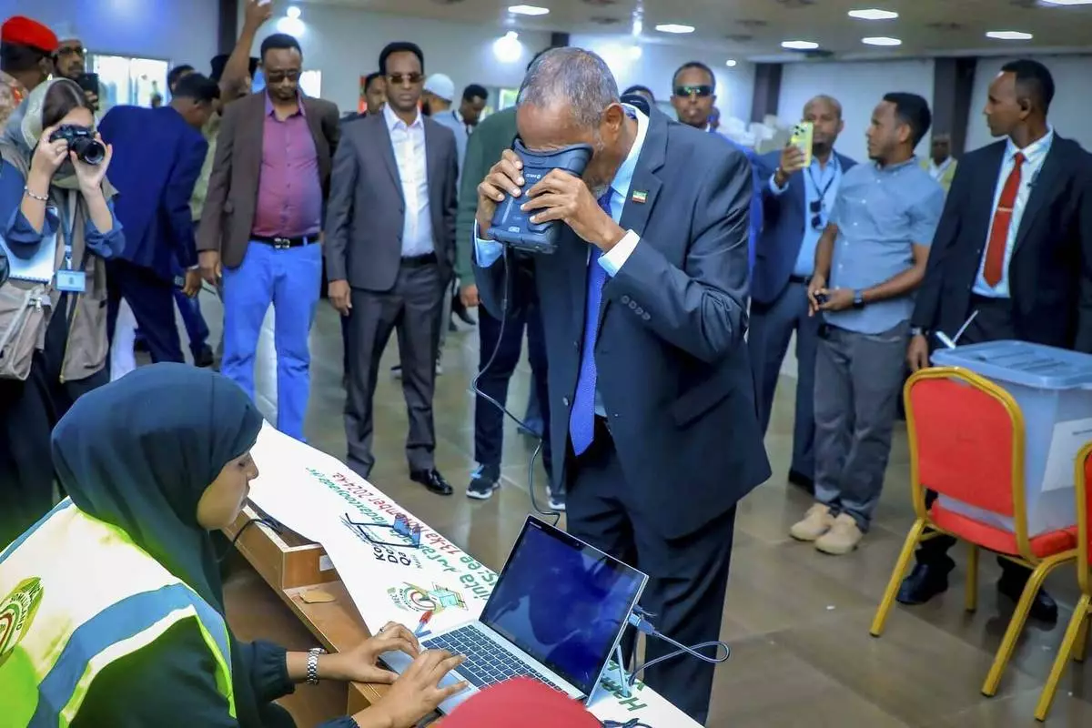 Somaliland President Muse Bihi Abdi, center, gets his biometrics registered before casting his vote inside a polling station during the presidential election in Hargeisa, Somaliland, Wednesday, Nov. 13,2024. (AP Photo/Abdirahman Aleeli)