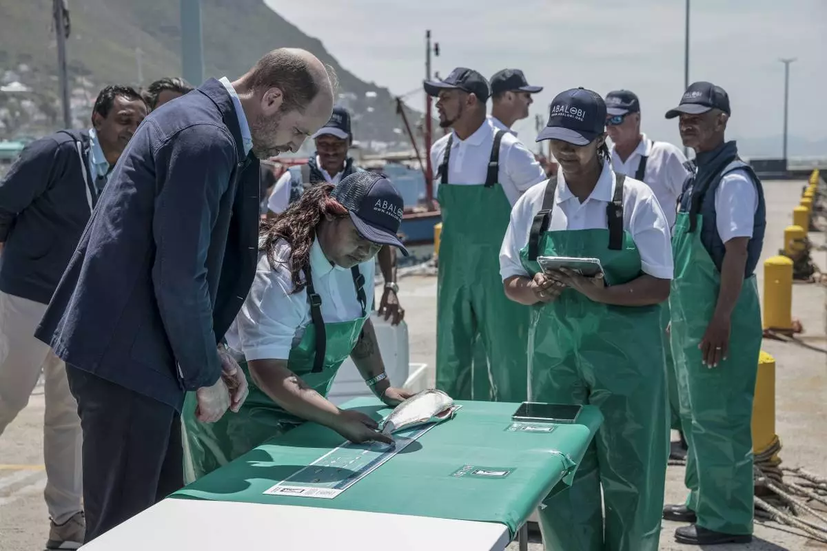 Britain's Prince William, the Prince of Wales, is shown 2023 Earthshot finalist ABALOBI's game-changing technology to register and log catches, to local fisherman, at Kalk Bay Harbour, near Cape Town, Thursday, Nov. 7, 2024. (Gianluigi Guercia/Pool Photo via AP)