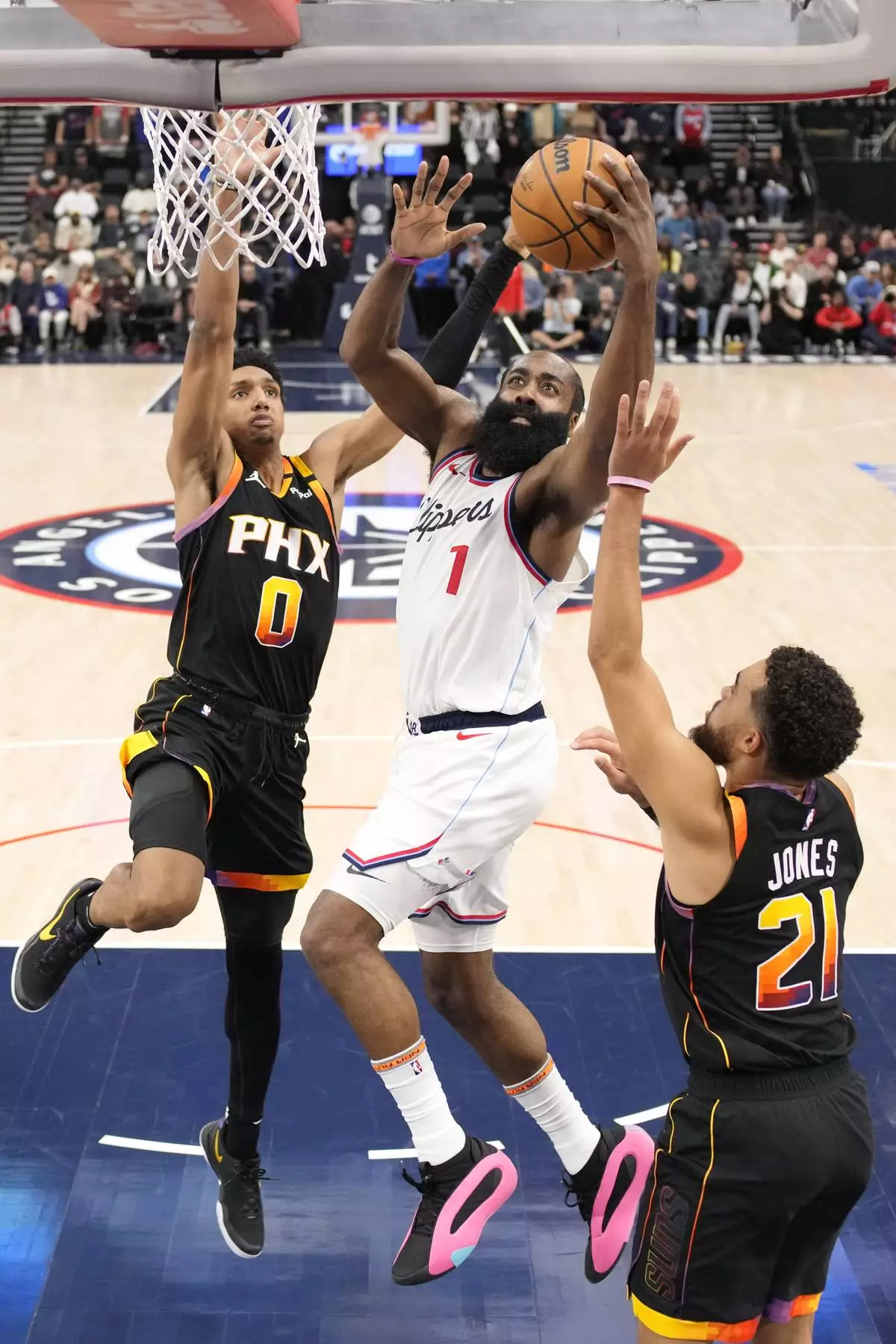 Los Angeles Clippers guard James Harden, center, shoots as Phoenix Suns forward Ryan Dunn, left, and guard Tyus Jones defend during the second half of an NBA basketball game, Thursday, Oct. 31, 2024, in Inglewood, Calif. (AP Photo/Mark J. Terrill)