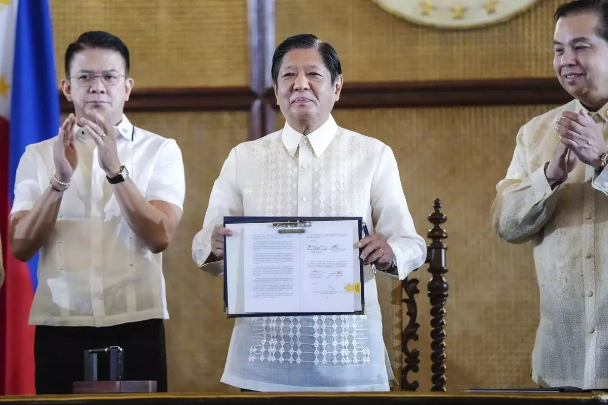 FILE - In this photo provided by the Malacanang Presidential Communications Office, Philippine President Ferdinand Marcos Jr., center, holds a document beside Senate President Francis Escudero, left, and House Speaker Martin Romualdez during the ceremonial signing of the Philippine Maritime Zones and Philippine Archipelagic Sea Lanes Act at the Malacanang presidential palace in Manila, Philippines, on Nov. 8, 2024. (Malacanang Presidential Communications Office via AP, file)