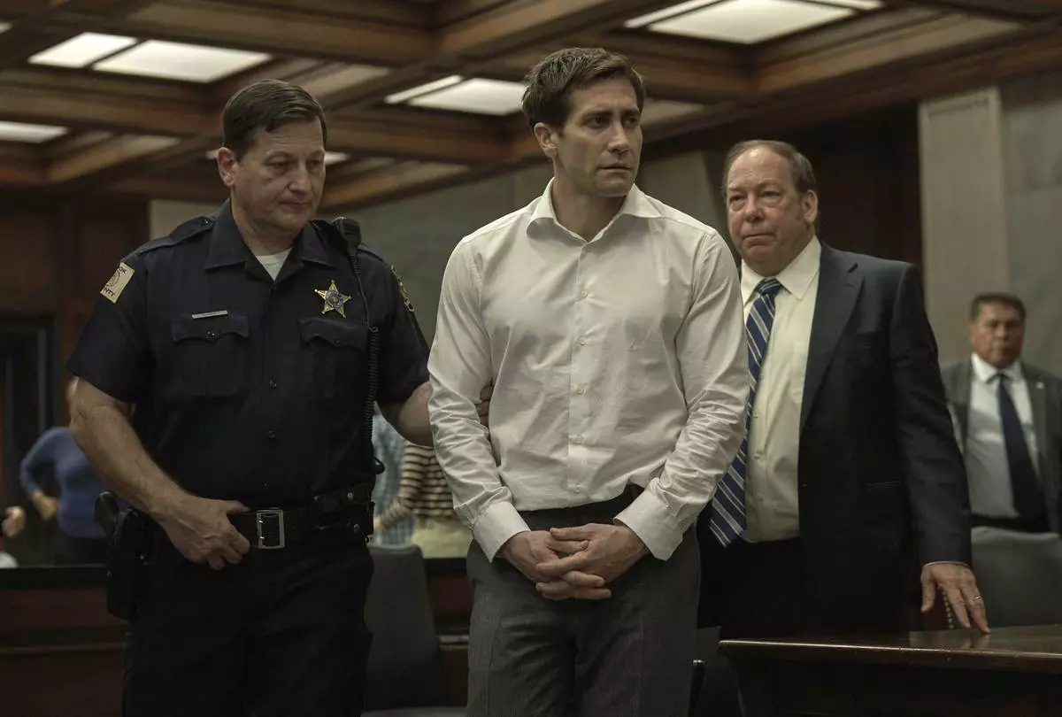 This image released by Apple TV+ shows Jake Gyllenhaal, center, and Bill Camp, right, in a scene from the series "Presumed Innocent." (Apple TV+ via AP)