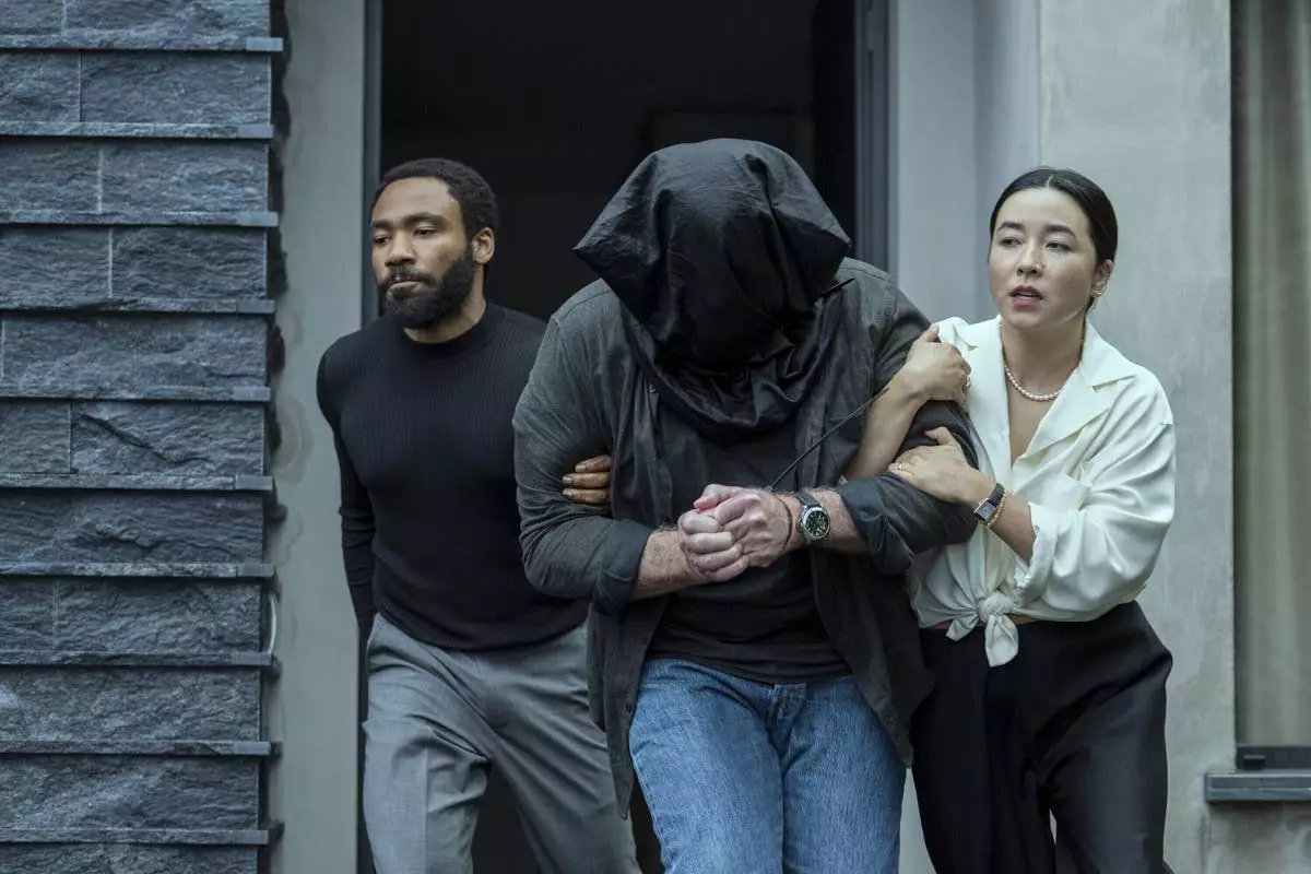 This image released by Prime Video shows Donald Glover, left, and Maya Erskine in a scene from "Mr. and Mrs. Smith." (David Lee/Prime Video via AP)