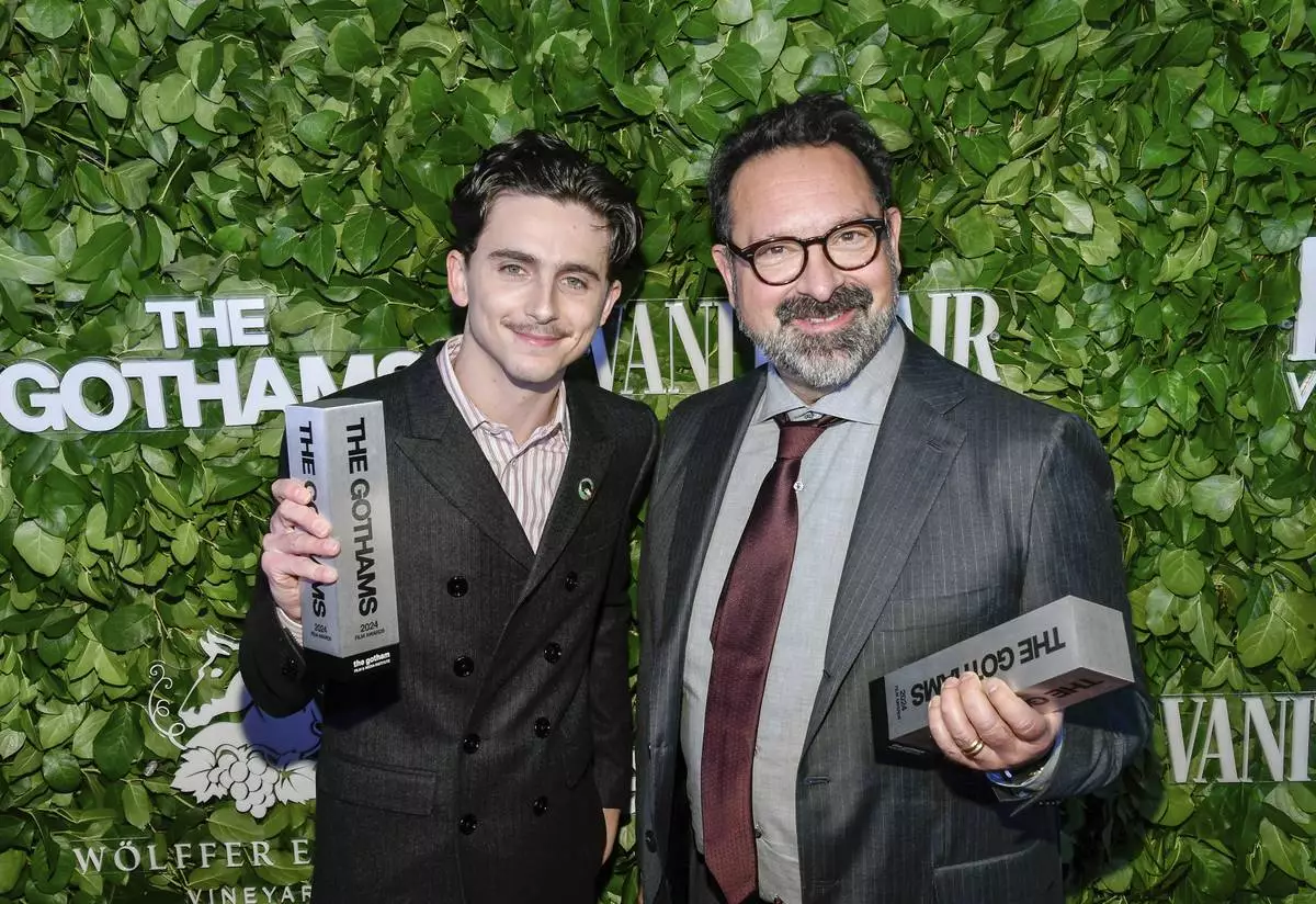 Timothee Chalamet, left, and James Mangold pose with the visionary tribute award for "A Complete Unknown" during The Gothams Film Awards at Cipriani Wall Street on Monday, Dec. 2, 2024, in New York. (Photo by Evan Agostini/Invision/AP)