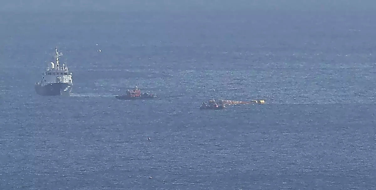 Members of South Korean coast guard conduct a search and rescue operation while they try to tow a capsized boat, right, in waters off Gyeongju, South Korea, Monday, Dec. 9, 2024. (Yoon Kwan-shik/Yonhap via AP)