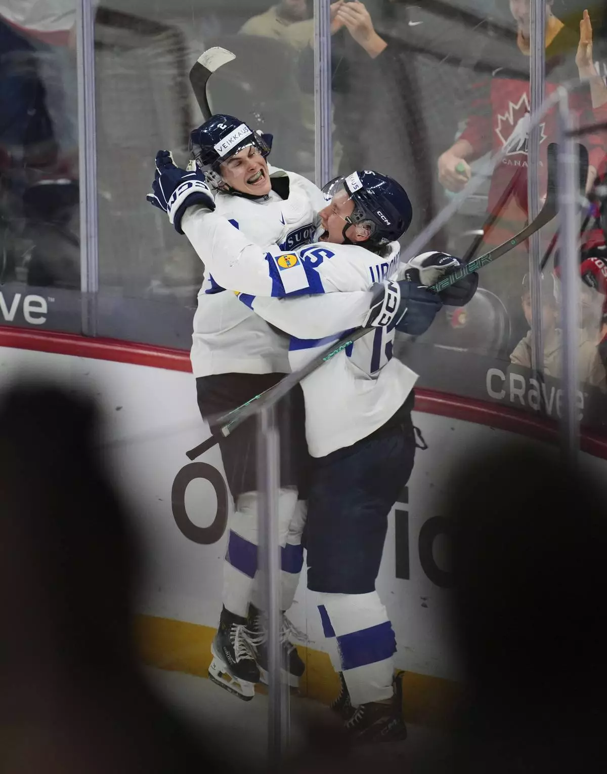 Finland forward Tuomas Uronen (15) celebrates with defenseman Mitja Jokinen (2) after scoring the overtime winning goal against United States goaltender Trey Augustine during IIHF World Junior Hockey Championship tournament game action in Ottawa, Ontario, Sunday, Dec. 29, 2024. (Sean Kilpatrick/The Canadian Press via AP)