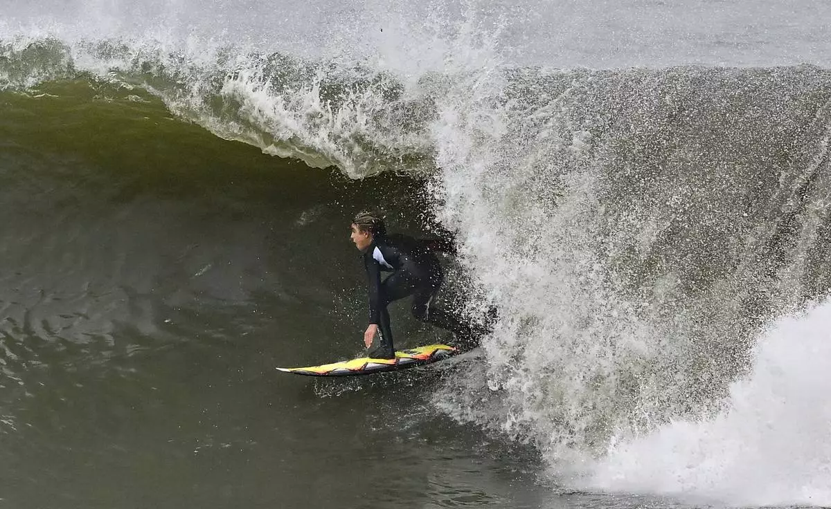 Surfers take to the water as big waves hit the shore in Seal Beach, Calif., Monday, Dec. 23, 2024. (Jeff Gritchen/The Orange County Register via AP)