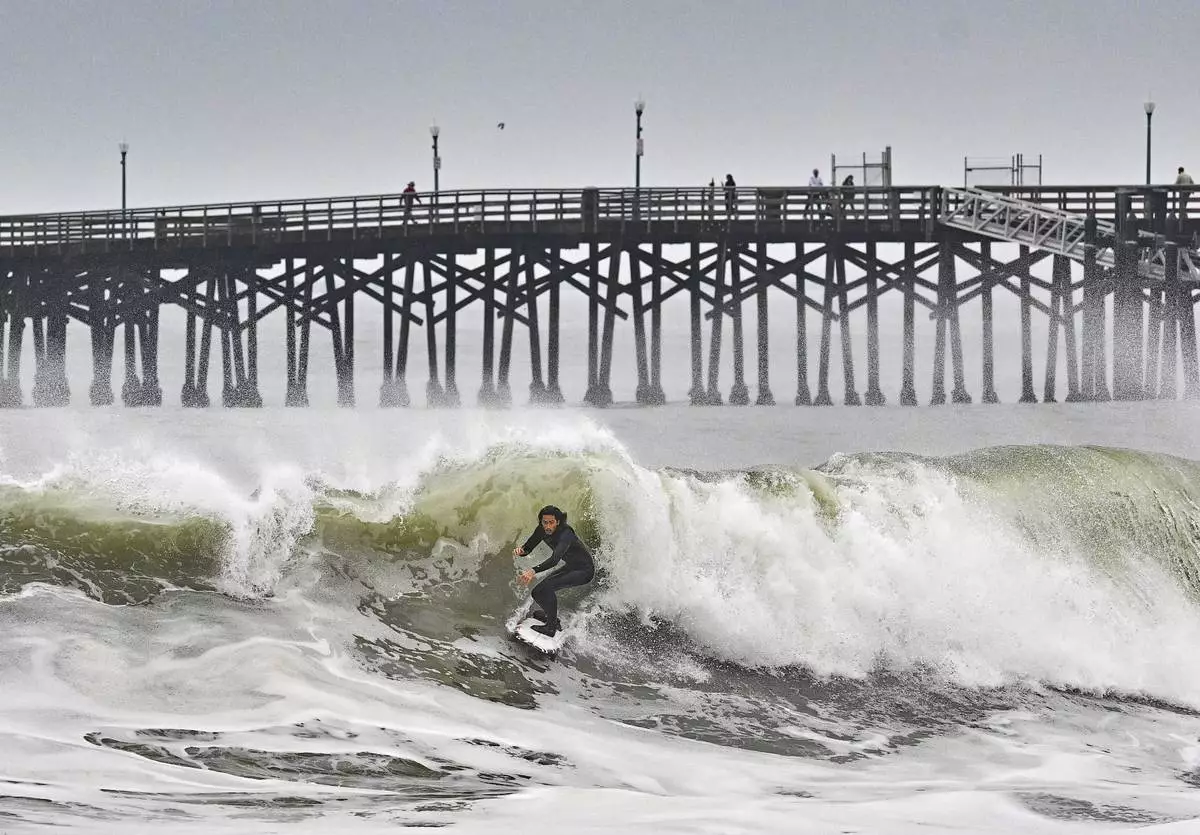 Surfers take to the water as big waves hit the shore in Seal Beach, Calif., Monday, Dec. 23, 2024. (Jeff Gritchen/The Orange County Register via AP)