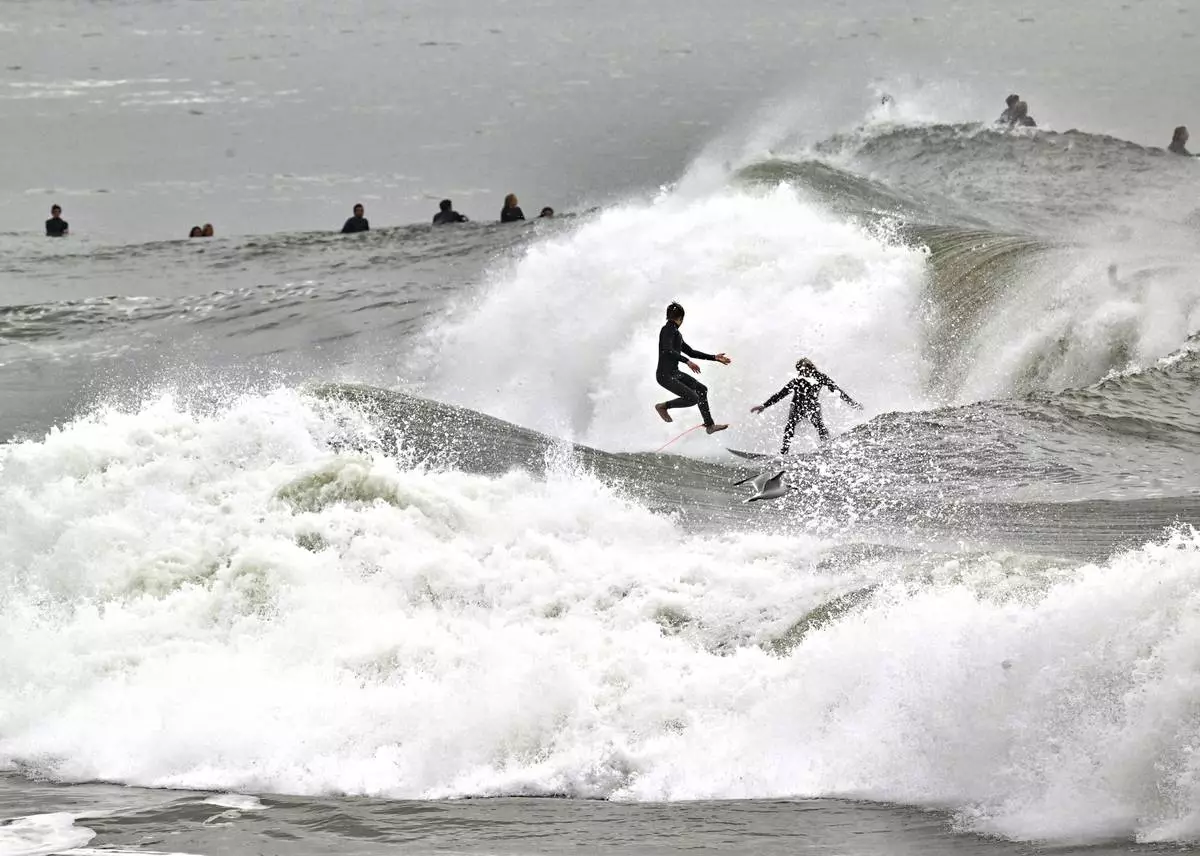 Surfers take to the water as big waves hit the shore in Seal Beach, Calif., Monday, Dec. 23, 2024. (Jeff Gritchen/The Orange County Register via AP)