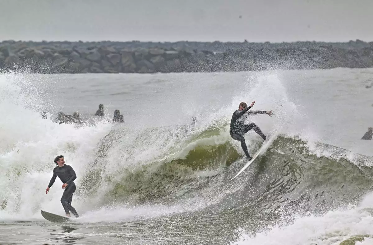 Surfers take to the water as big waves hit the shore in Seal Beach, Calif., Monday, Dec, 23, 2024. (Jeff Gritchen/The Orange County Register via AP)